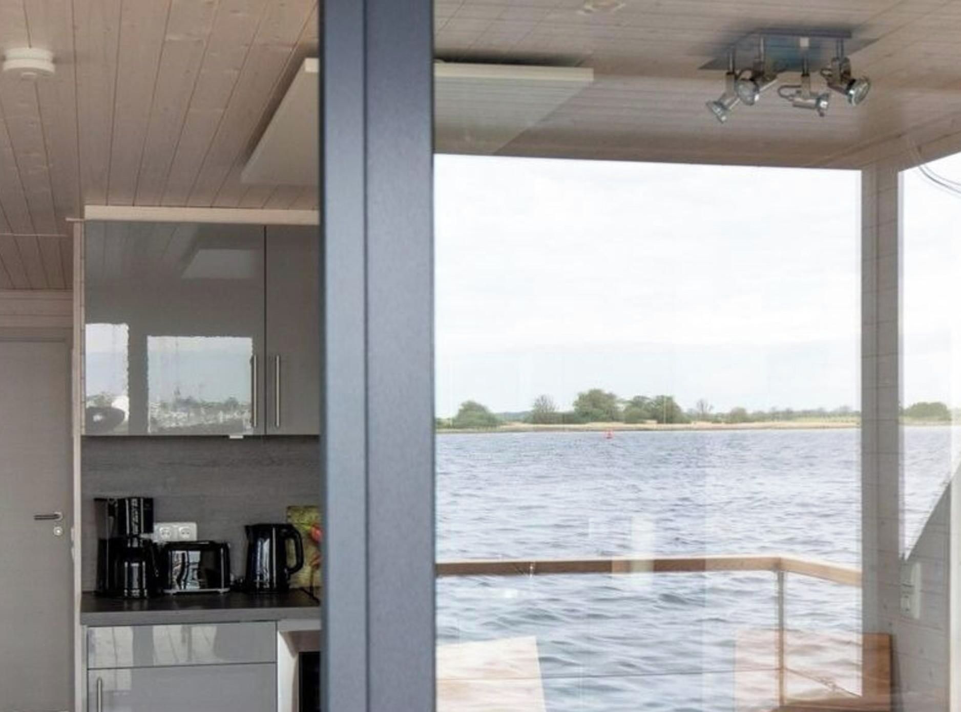A modern kitchen with a view of a body of water.