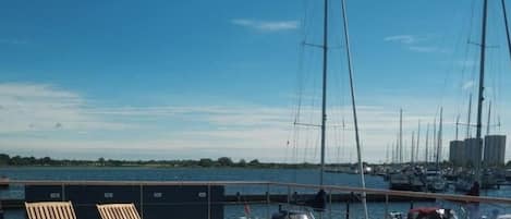 Un puerto deportivo con sillones de madera y una vista despejada del agua.