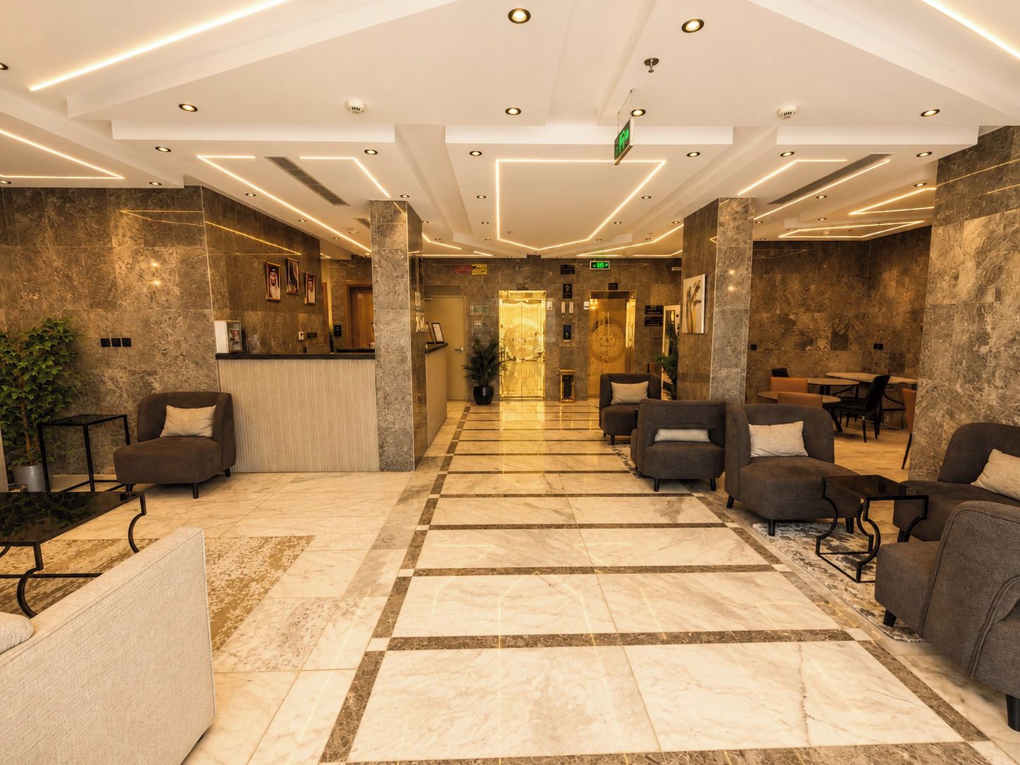 Una hall d'albergo con reception, area salotto e banco accettazione.