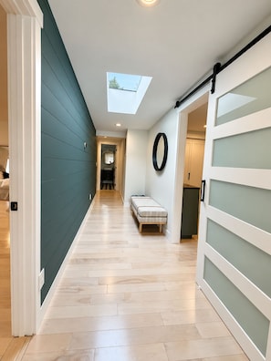 A hallway with a skylight, a bench, and a sliding door. - Lake Sawyer Waterfront Retreat with Private Dock, Near Skiing and Mt. Rainier (Black Diamond)