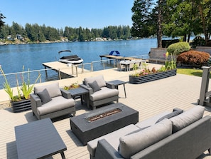 A deck with outdoor furniture, a barbecue grill, and a view of a lake. - Lake Sawyer Waterfront Retreat with Private Dock, Near Skiing and Mt. Rainier (Black Diamond)