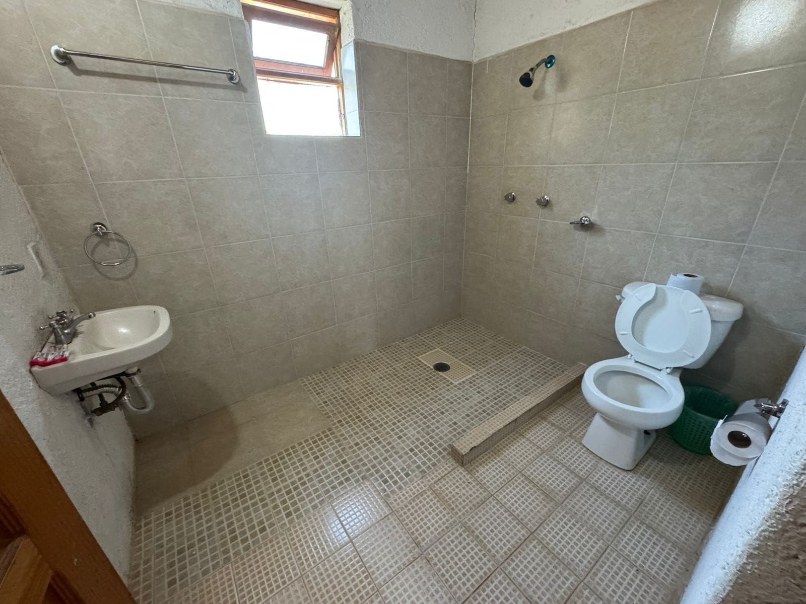 A small bathroom with a shower, toilet, and sink.