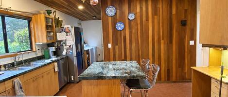 A modern kitchen with wooden paneling, a central island, and a skylight.
