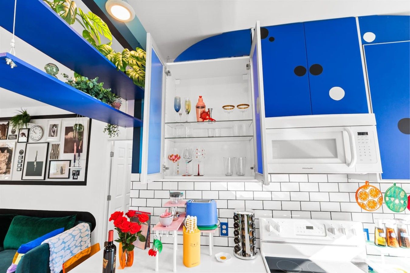 Une cuisine moderne avec des meubles blancs, un four à micro-ondes et divers appareils de cuisine.