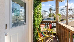 A balcony with a wooden railing, a green vertical garden, and a table with colorful chairs. - Colorful Retro Pop-Art Bungalow In Midtown (Sacramento)