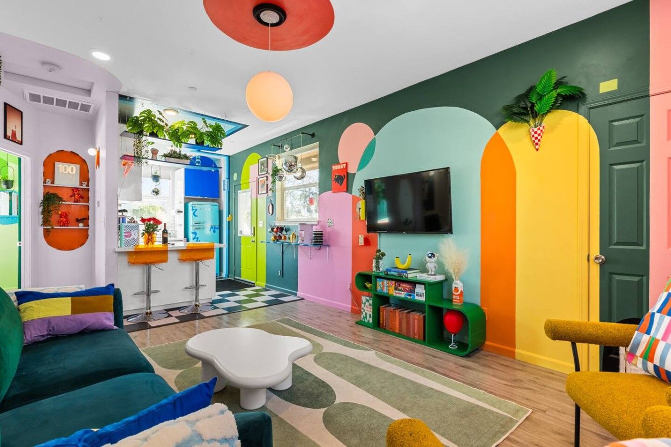 Ein lebhaftes Wohnzimmer mit einem Schachbrettmuster-Bodenbelag, einem weißen Couchtisch und bunten Sofas.