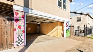 A residential garage with a wooden door, a stop sign, and a concrete driveway. - Colorful Retro Pop-Art Bungalow In Midtown (Sacramento)