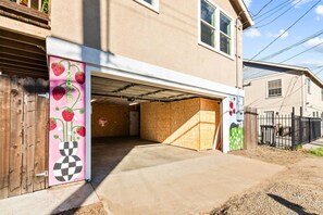 Eine Garage mit Wohnhäusern, einer Holztür, einem Stoppschild und einem Betonauffahrt.