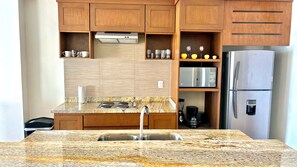 A kitchen with granite countertops, stainless steel appliances, wooden cabinets, and a built-in oven. - Oceanview 3-Bedroom Condo, Infinity Pool & Parking – Zona Dorada, Mazatlán (Mazatlán)