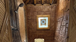Ein Badezimmer mit Toilette, Dusche und einem kleinen Fenster.