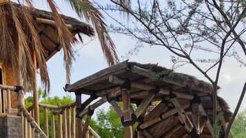A stone staircase leading to a wooden gazebo with a thatched roof.