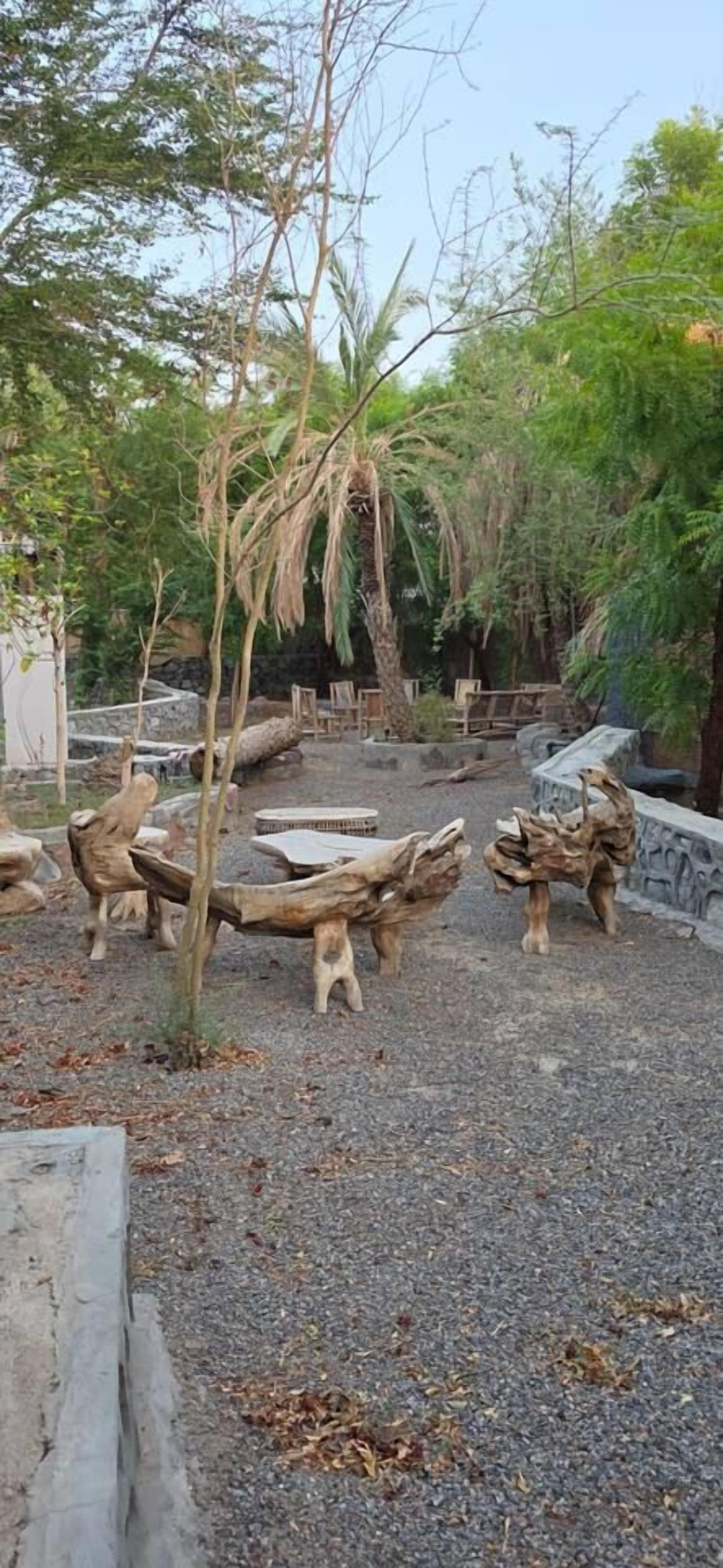 A garden with wooden sculptures and a gravel path.