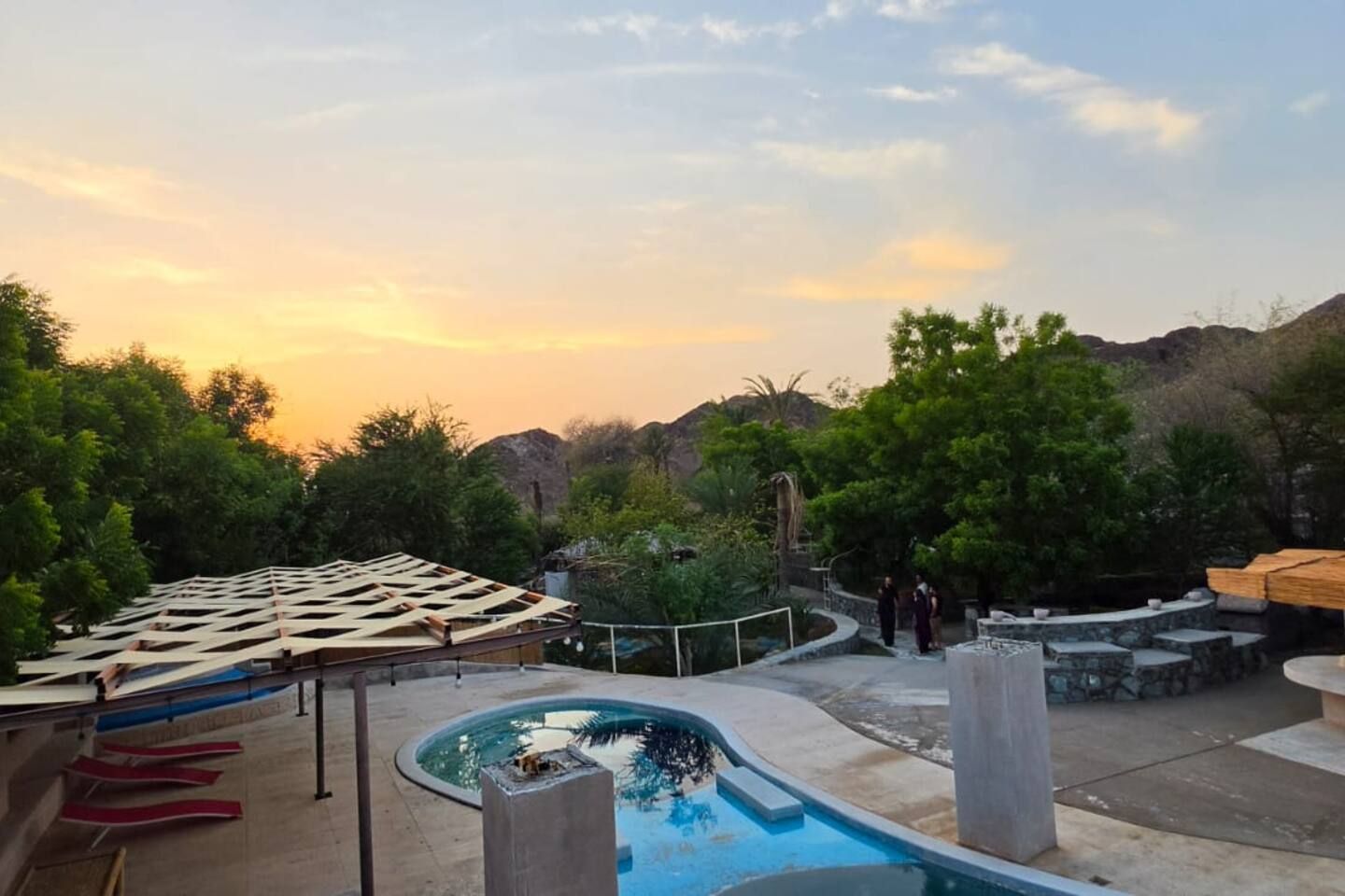 A rooftop pool area with a view of the surrounding landscape, including trees and hills.