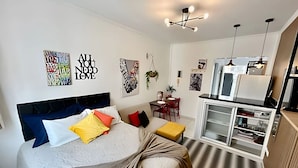 A modern bedroom with a bed, bedside table, and a built-in wardrobe. - SHB - Studio no Gonzaga à Beira Mar (Santos)