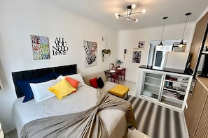 A modern bedroom with a bed, bedside table, and a built-in wardrobe. - SHB - Studio no Gonzaga à Beira Mar (Santos)