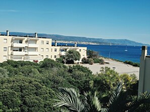A residential area with buildings, a clear sky, and a view of the sea. - Zefiro Apartment in Alghero. The perfect place to visit the Coral Riviera (Fertilia)