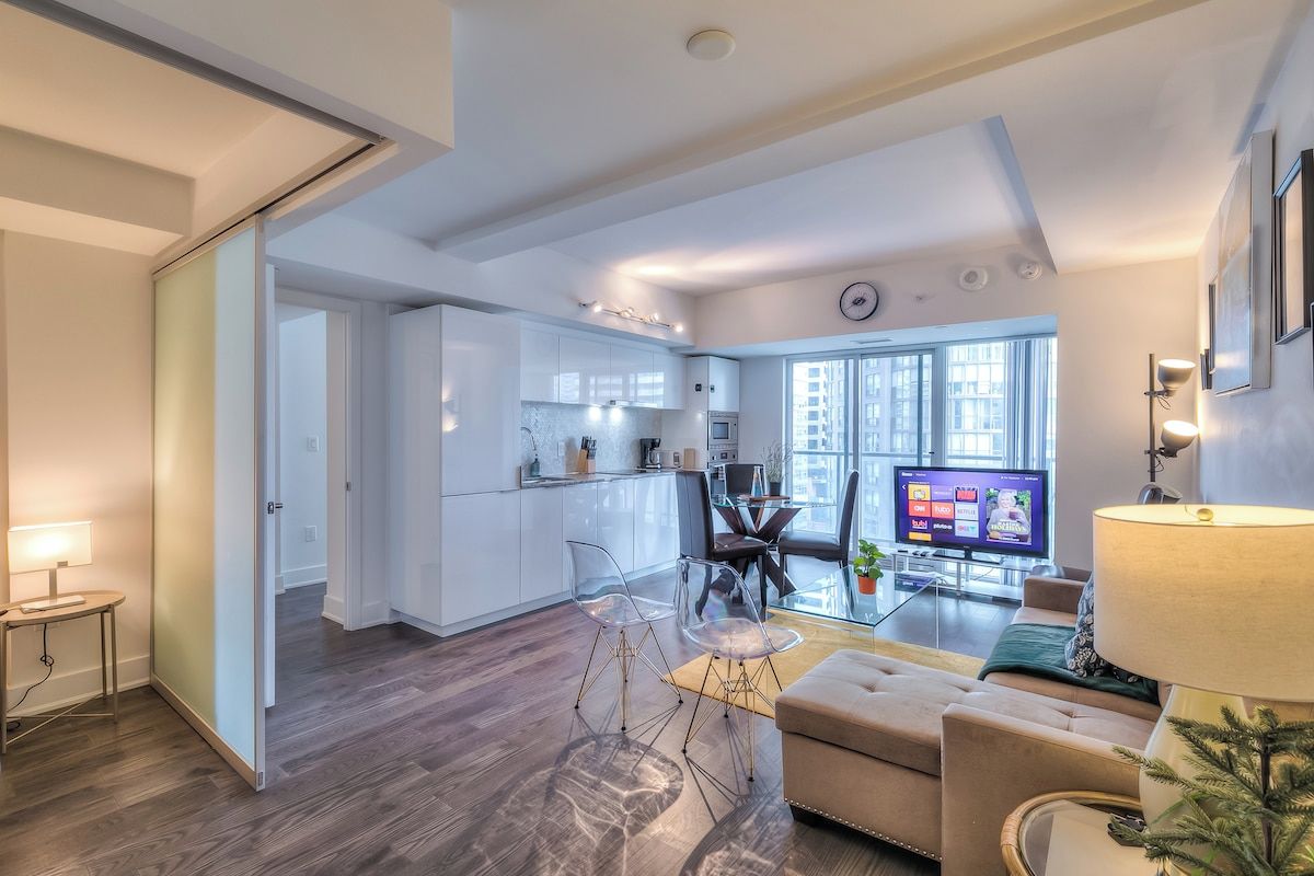 A modern apartment with a kitchen, dining area, and living room.