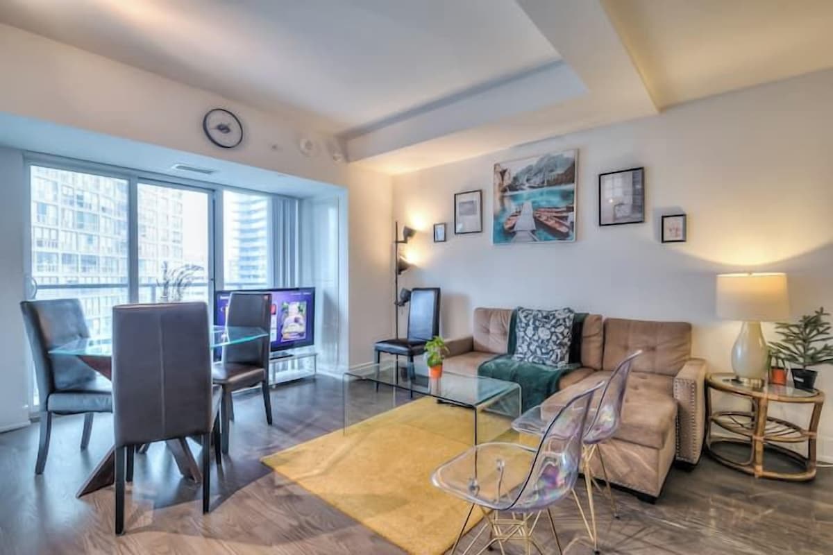 A modern living room with a sofa, chairs, a coffee table, and a TV.