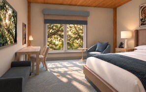 A hotel room with a bed, a desk, a chair, a bedside table, and a window with a view of trees. - Sabal House (Savannah)