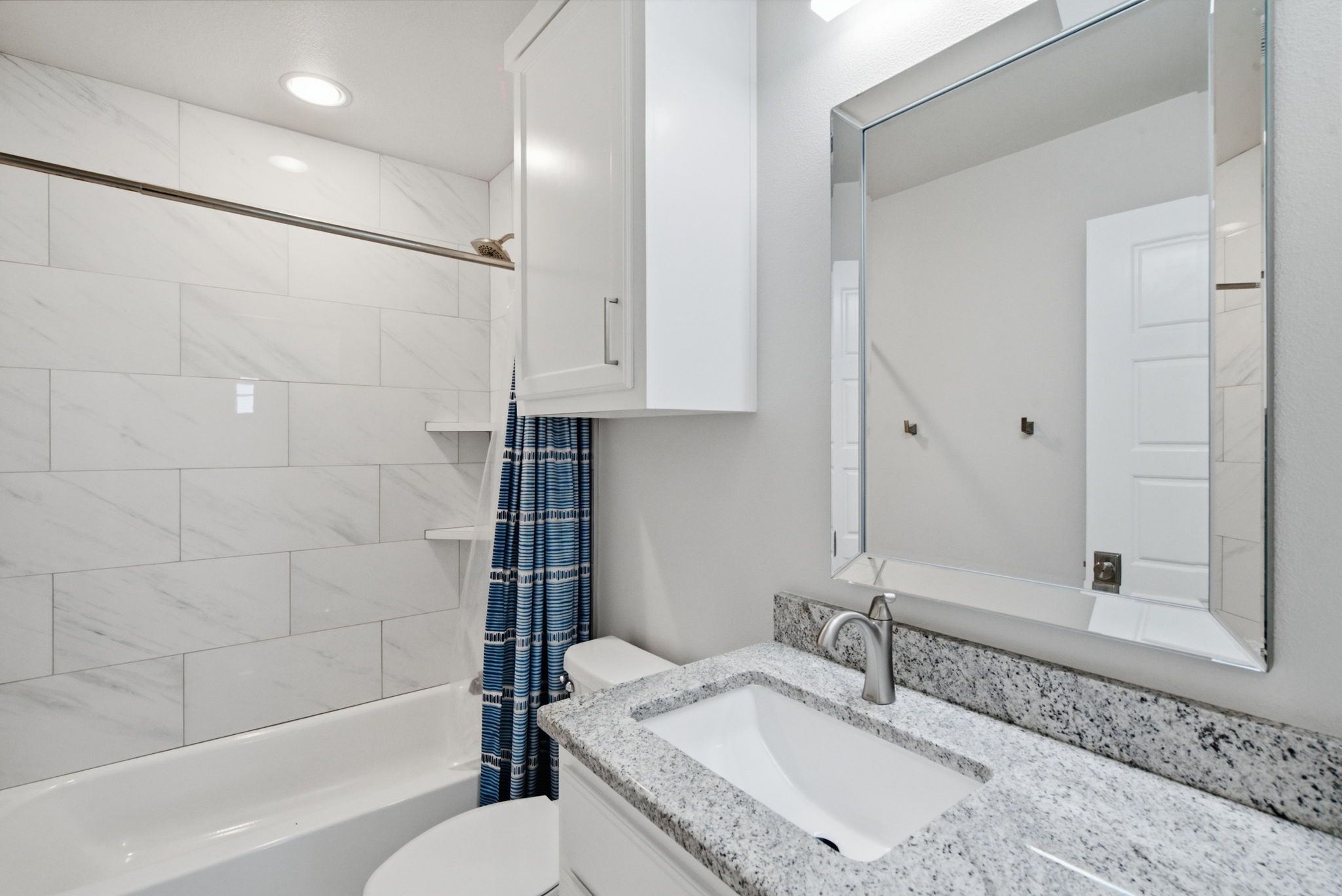 A modern bathroom with a bathtub, toilet, and sink.