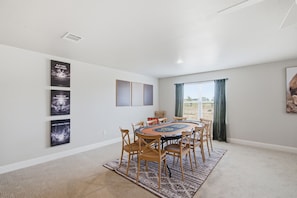 A room with a round table, chairs, and a carpet.