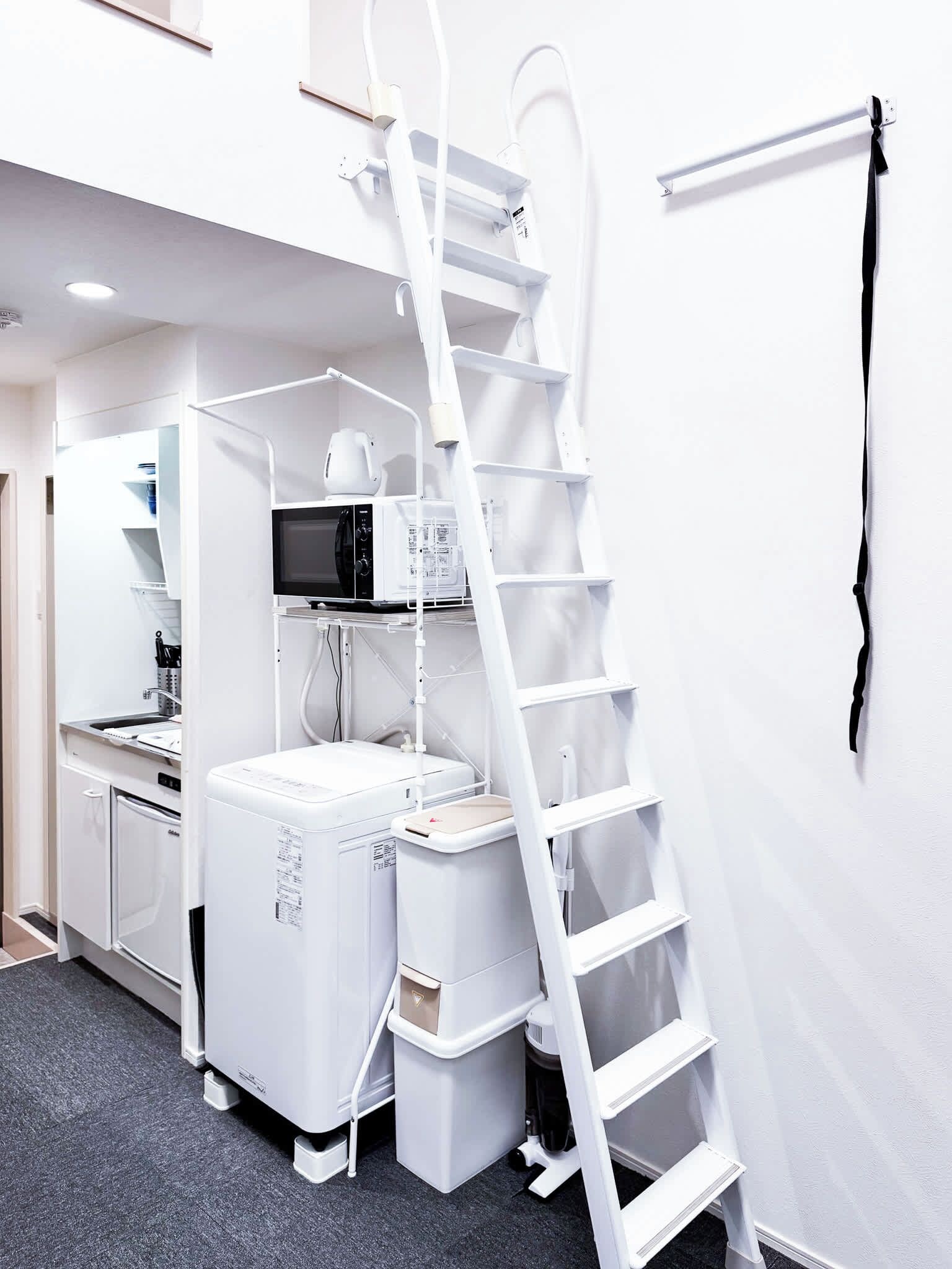 A compact kitchen with a microwave, coffee maker, and a white refrigerator.