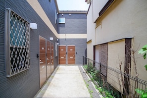 A narrow alleyway with a concrete path, metal fences, and wooden doors. - Triphome Tateishi Free WiFi Asakusa SkyTree (Katsushika City)