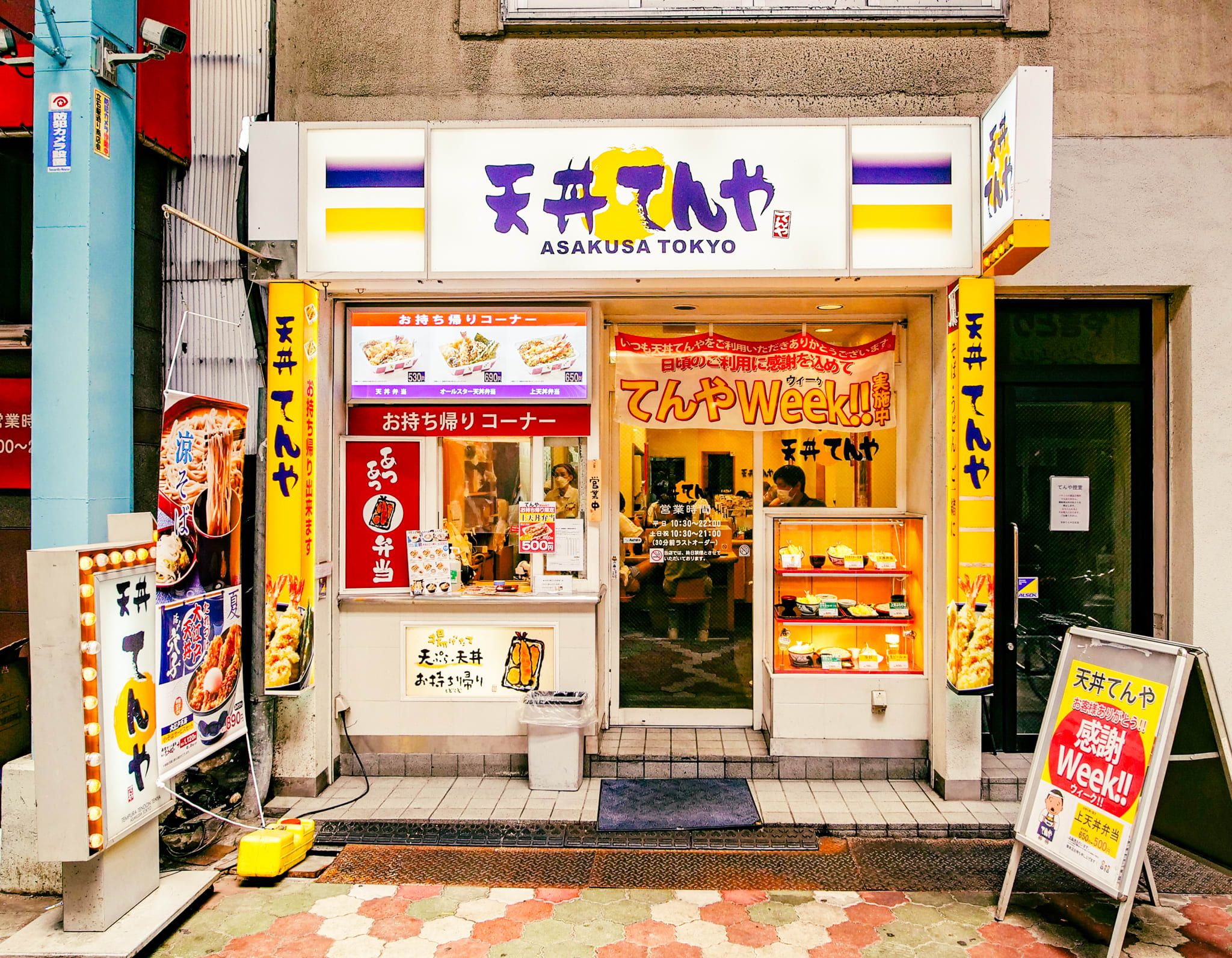 A storefront with a sign reading 'Asakusa Tokyo' and various food advertisements.