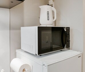Fornet blanc amb quadre de control negre sobre una superfície de cuina blanca.