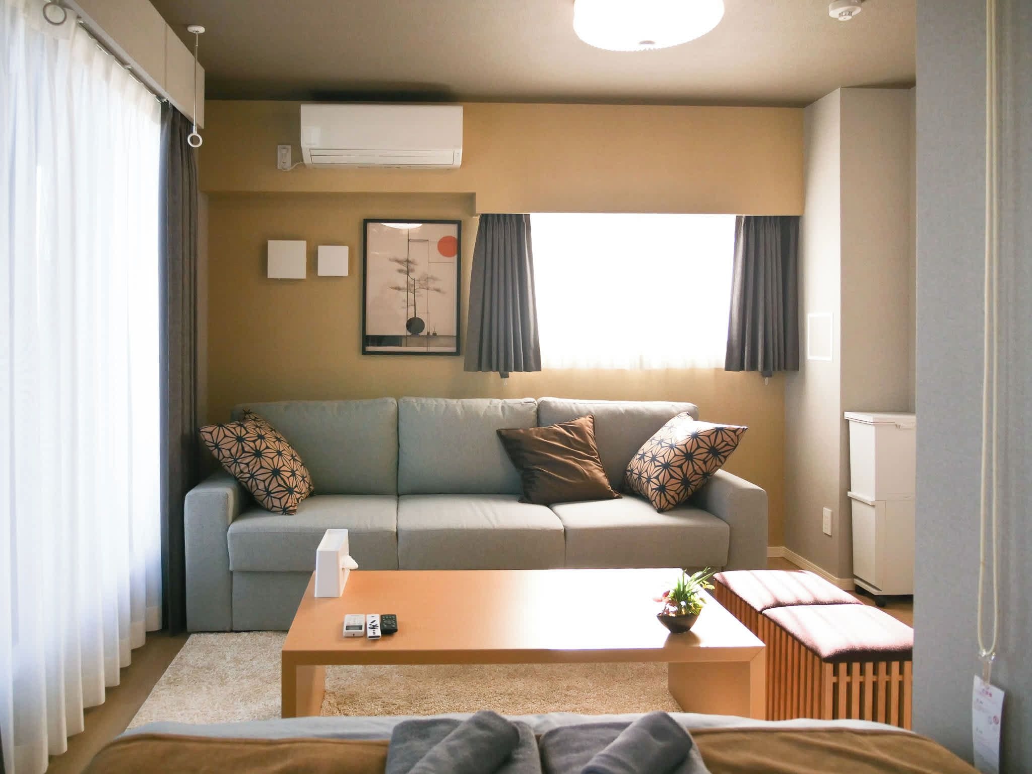A modern living room with a grey sofa, a wooden coffee table, and a radiator.