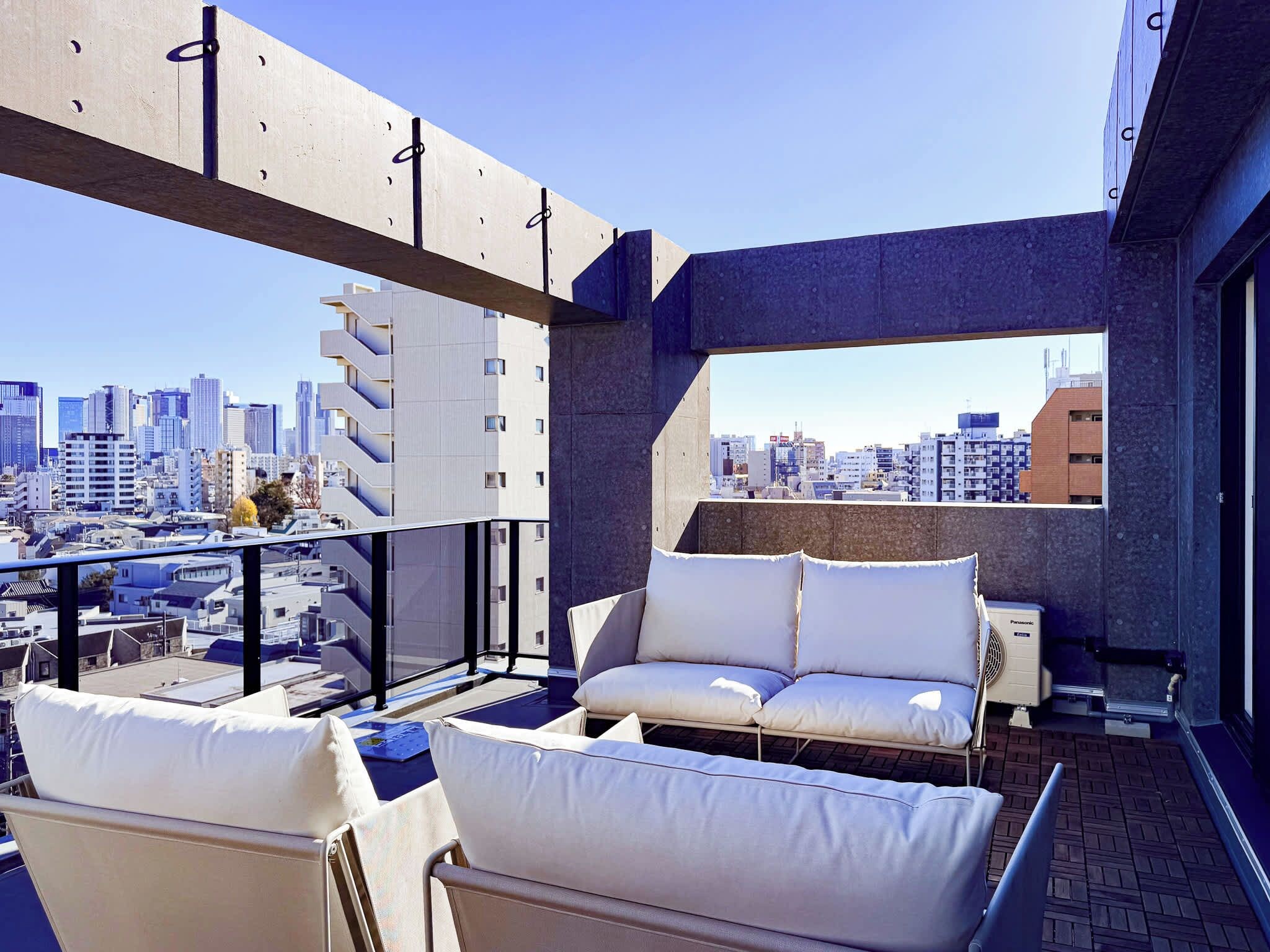 A balcony with a city view, a sofa, and a fan.
