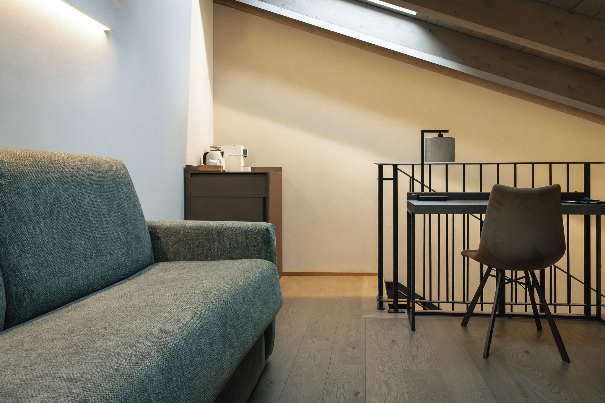 Ein modernes Schlafzimmer im Loft-Stil mit einer Couch, einem Schreibtisch und einem Sessel.