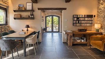 Un interior moderno con comedor, cocina y estantería.