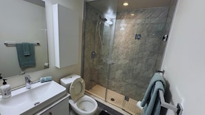 A bathroom with a toilet, sink, and shower. - Central Toronto Suites (Toronto)