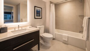 Ein modernes Badezimmer mit großem Spiegel, zwei Waschbecken, Toilette und Badewanne.