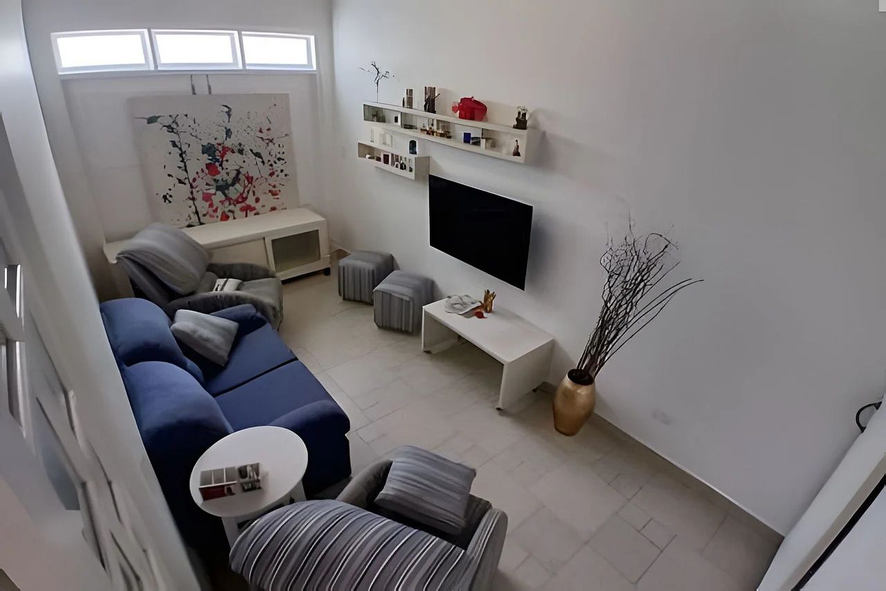 Una sala de estar moderna con un sofá modular, un televisor de pantalla plana y estanterías empotradas.