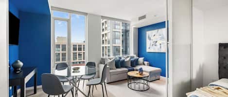 Um apartamento moderno com área de jantar, sofá e cama.