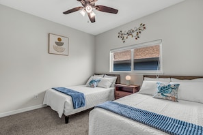 A bedroom with two beds, a ceiling fan, a window with blinds, and a wall-mounted artwork. - Waterfront Oasis Bay Views near NASA & Kemah (Seabrook)