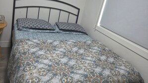 Une chambre à coucher avec un lit, une horloge murale et une fenêtre.