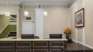 A reception area with a counter, chairs, a fire command center sign, a staircase, and a framed picture on the wall.