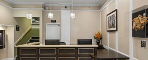 A reception area with a counter, chairs, a fire command center sign, a staircase, and a framed picture on the wall.