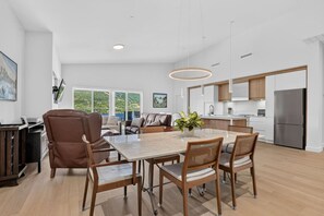 Eine moderne Küche mit einer großen Kochinsel, Holzschränken und einem Edelstahlkühlschrank.