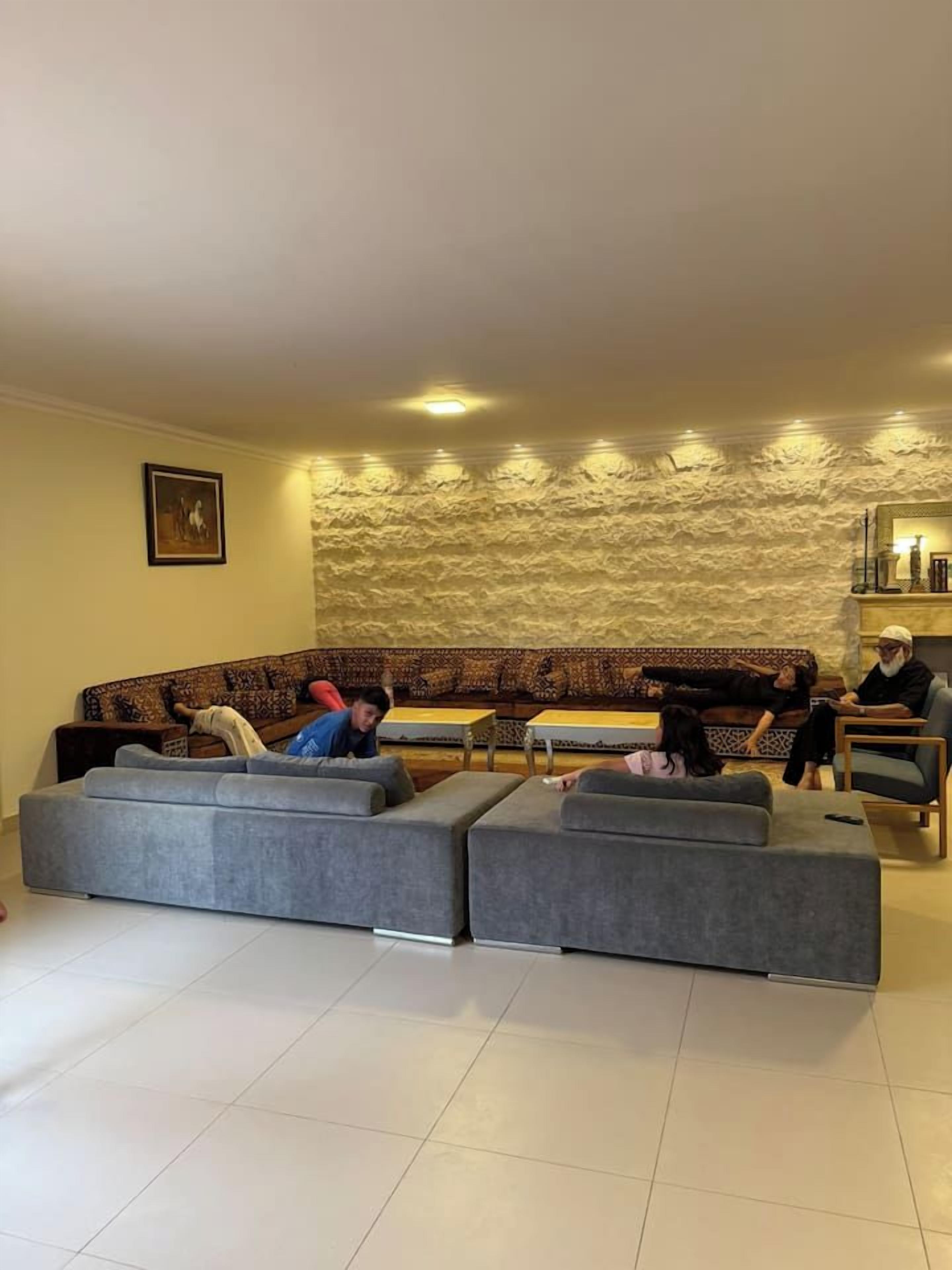 Una sala de estar con un sofá modular, una mesa de centro y una chimenea.