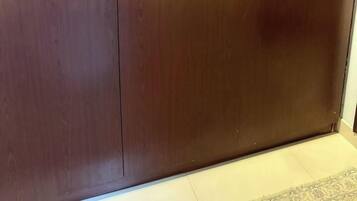 A large wooden wardrobe with two doors and a handle on each door.