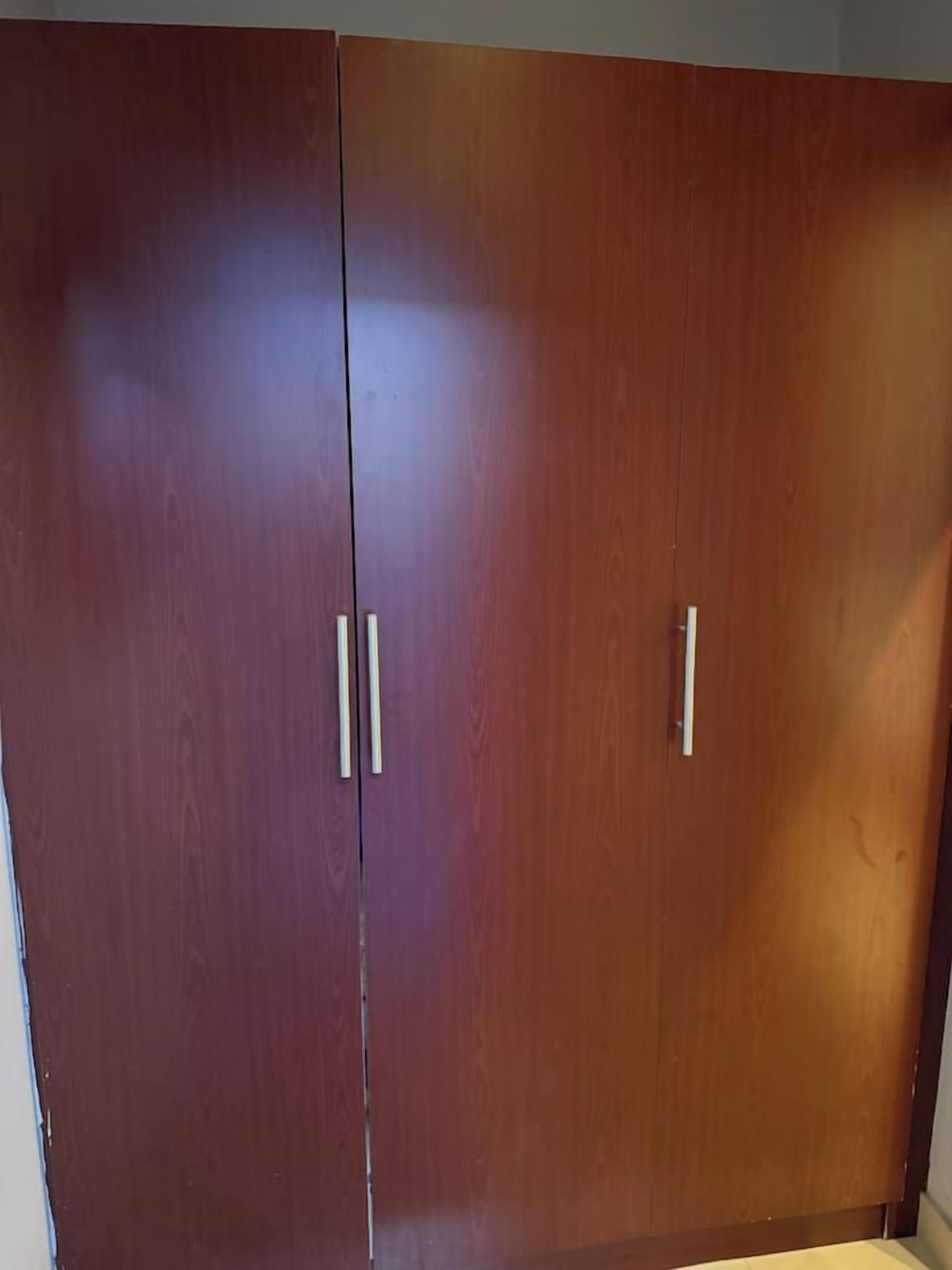Un armario de madera con dos puertas y dos tiradores.