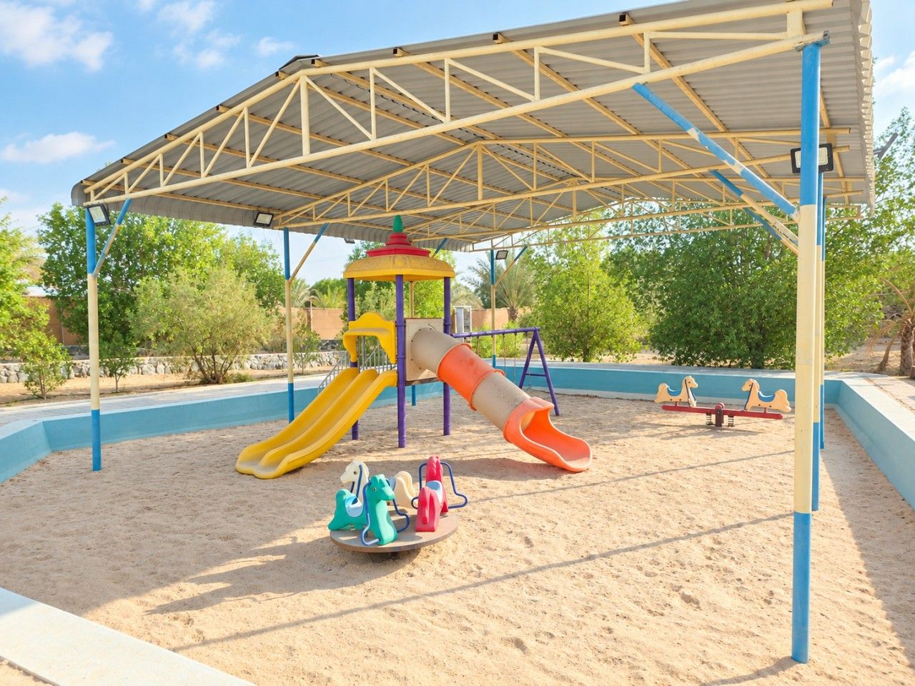 A playground with a slide, swings, and a climbing structure.