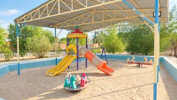 A playground with a slide, swings, and a climbing structure.
