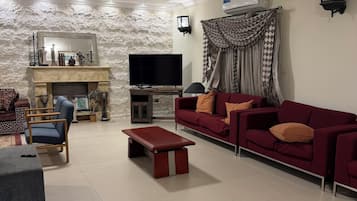 A living room with a fireplace, a television, a sofa, and a coffee table.