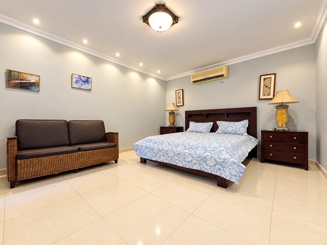 A bedroom with a bed, a sofa, and a nightstand.