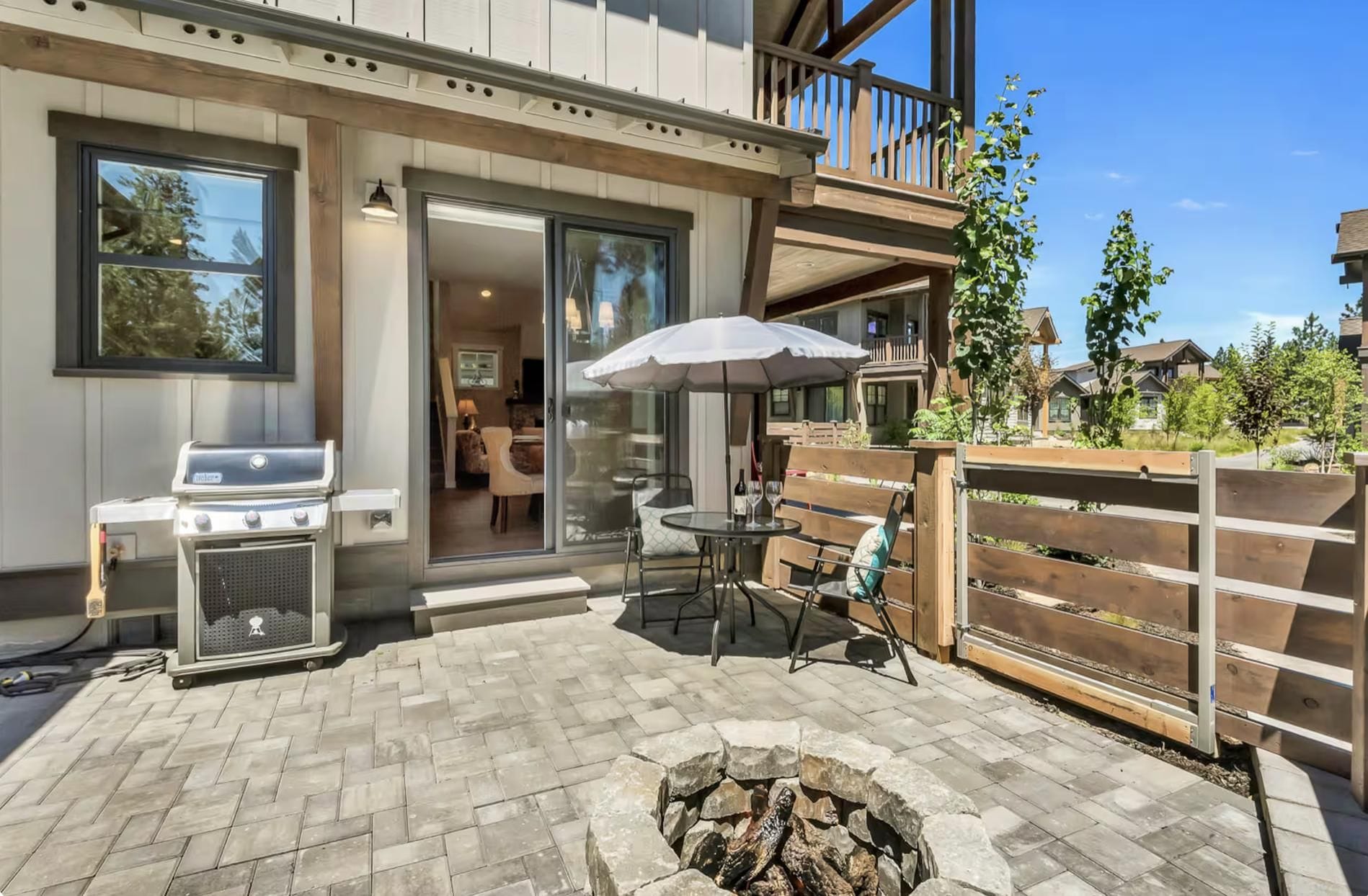 A patio with a grill, outdoor seating, and a fire pit.